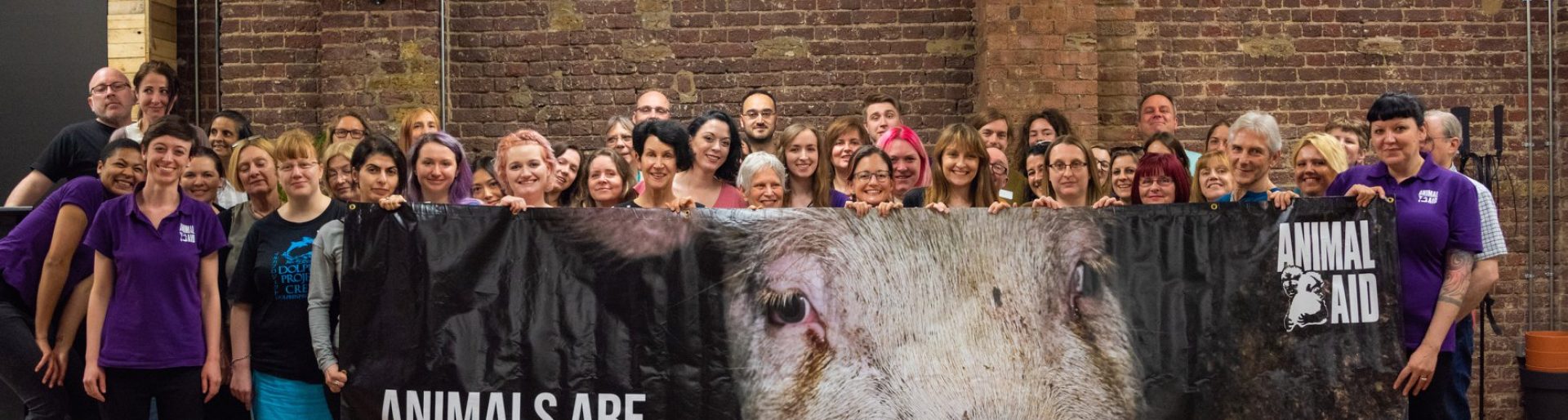 A group of people are standing behind a banner that reads Animals are not food