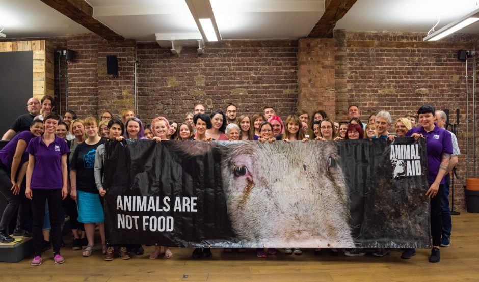 A group of people are standing behind a banner that reads Animals are not food