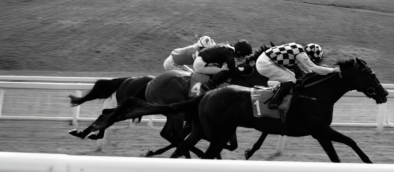 Black and white picture of horses and riders on track