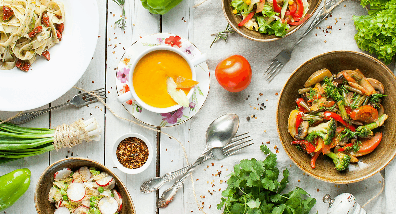 Bowls of colourful food arranged on a white wooden table