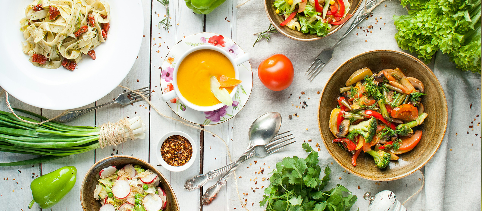 Bowls of colourful food arranged on a white wooden table