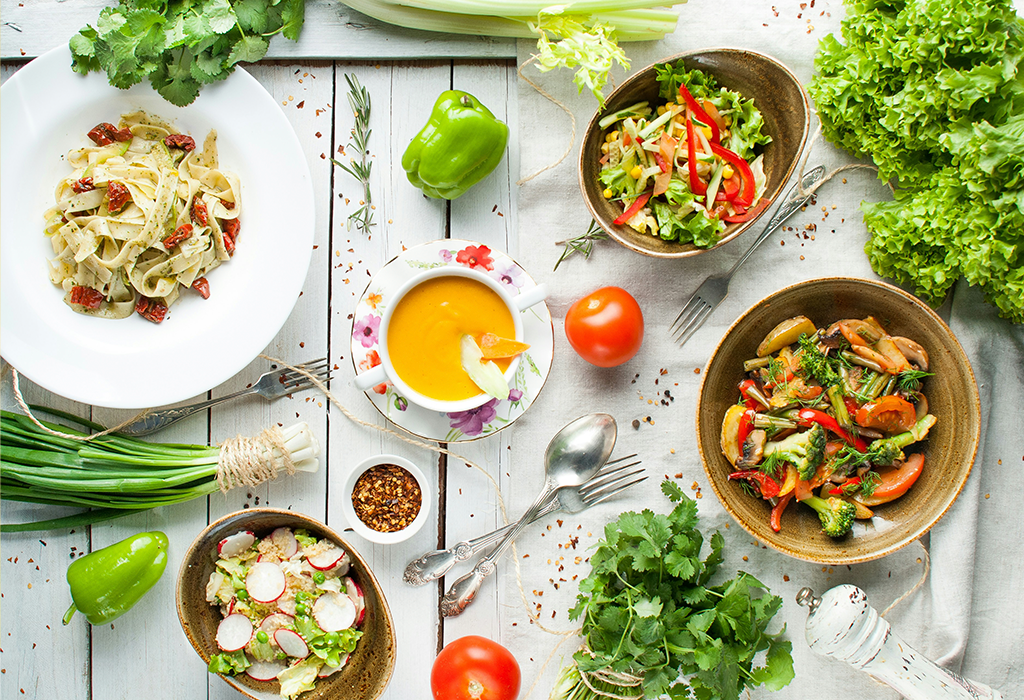 Bowls of colourful food arranged on a white wooden table