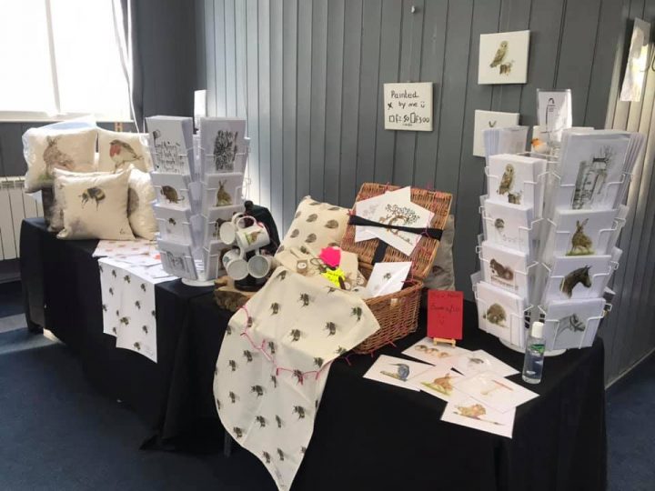 The image shows a stand with the artist's art cards for sale
