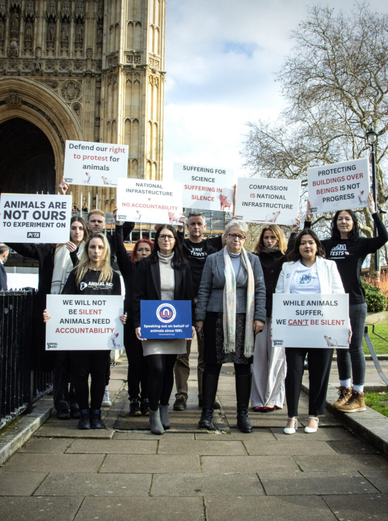 Protesters standing together outside of the Houses of Parliament.